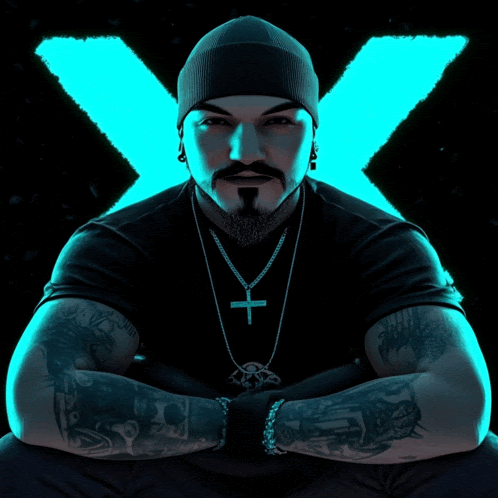 a man wearing a black shirt and a cross necklace with an x in the background