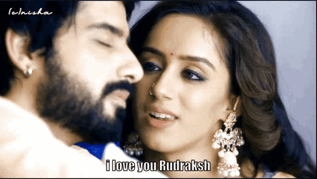 a man with a beard kisses a woman on the cheek and says " i love you rudrakshi "