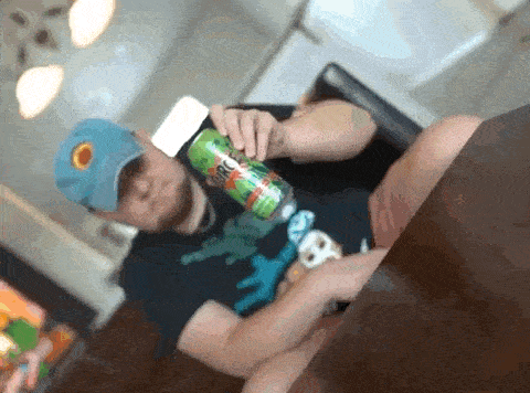 a man is sitting at a table holding a can of a drink that says circus