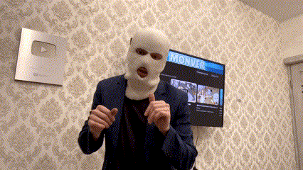 a man wearing a ski mask is giving a thumbs up in front of a tv that says monker