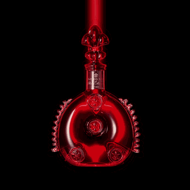a bottle of louis xiii cognac is lit up in red