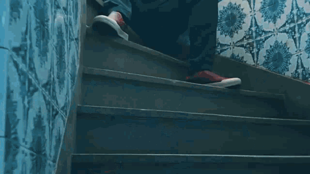 a man is sitting on a set of stairs holding a cell phone in his hand .