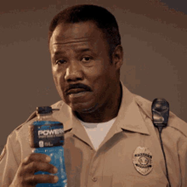 a police officer is holding a bottle of power water