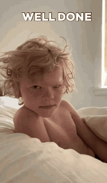 a shirtless child laying on a bed with the words well done written above him