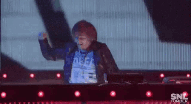 a man is dancing on a stage in front of a snl logo .