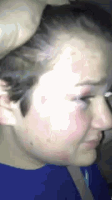 a close up of a girl 's face with a blue shirt on