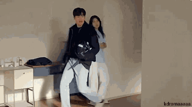 a man and a woman are dancing together in a living room .