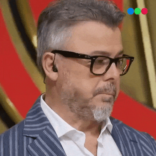 a man with glasses and a beard is wearing a blue striped jacket