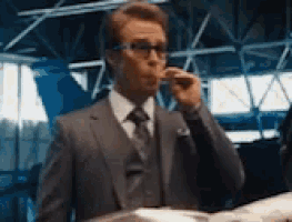 a man in a suit is smoking a cigarette