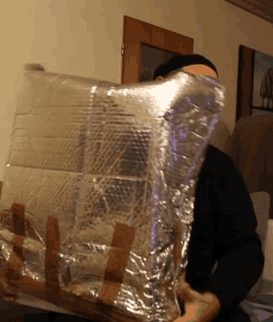 a man holding a piece of aluminum foil