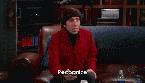 a man in a red jacket is sitting on a couch with the word recognize below him