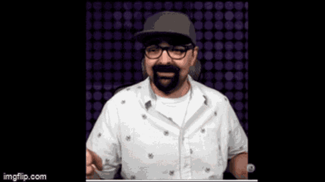 a man with a beard and glasses is wearing a hat and a white shirt