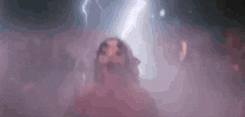 a blurred image of a person standing in a dark room with a lightning bolt coming from the sky .
