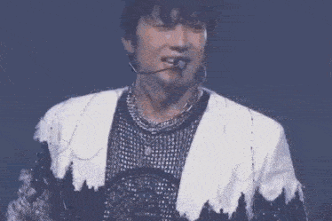 a close up of a man wearing a microphone and a necklace .