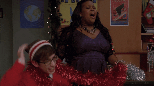 a woman in a purple dress sings in front of a poster that says be on time