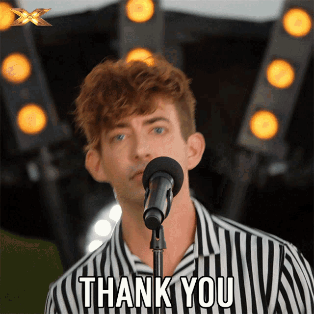 a man singing into a microphone with the words thank you written below him
