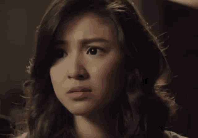 a close up of a woman 's face with a serious look