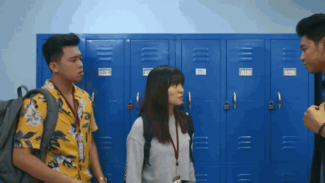 a woman stands in front of a row of blue lockers with the numbers 1 through 12 on them