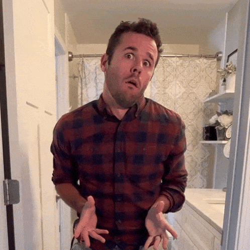 a man in a plaid shirt is making a funny face