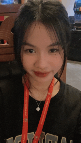 a girl with a lanyard around her neck that says ' aasia '
