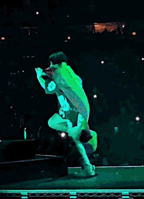 a person is standing on a stage holding a rainbow flag