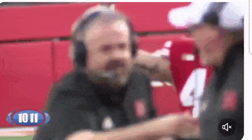 a blurred image of a man wearing headphones and a number 4 shirt
