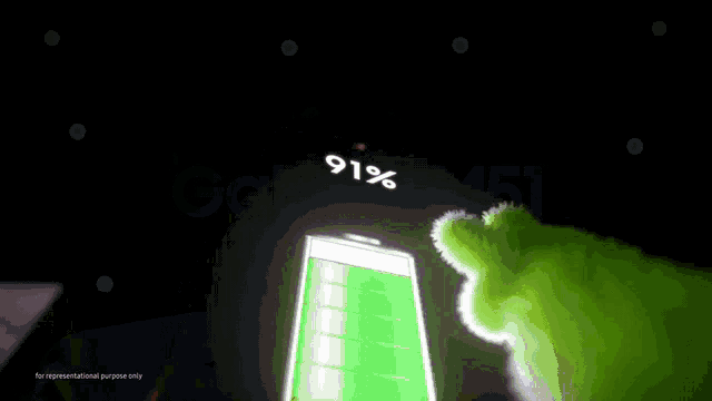 a green stuffed animal is sitting on top of a black phone