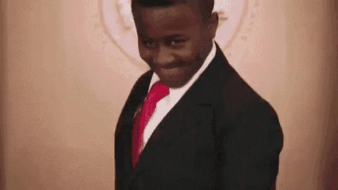a young man in a suit and tie is smiling .