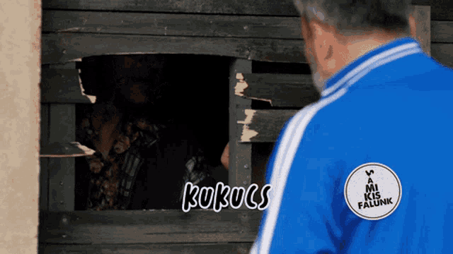 a man in a blue jacket has a sticker on his back that says " kukucs "