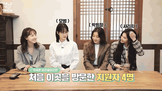 a group of women sitting at a table with twice written on the top left