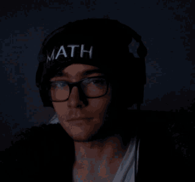 a man wearing glasses and a hat with the word math on it