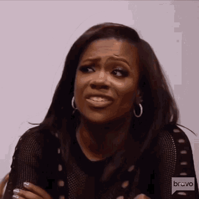 a woman is making a funny face while wearing hoop earrings .