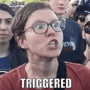 a woman wearing glasses is making a funny face while standing in a crowd .