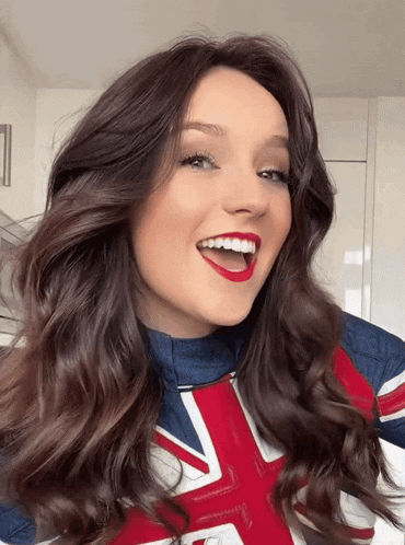 a woman with red lipstick is wearing a british flag outfit