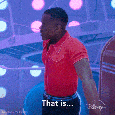 a man in a red shirt is standing in front of a disney+ logo