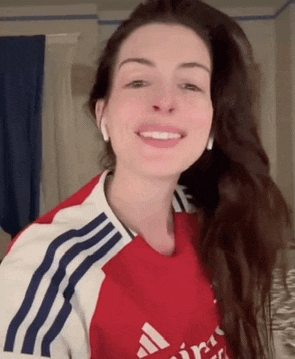 a woman is wearing a red and white adidas shirt