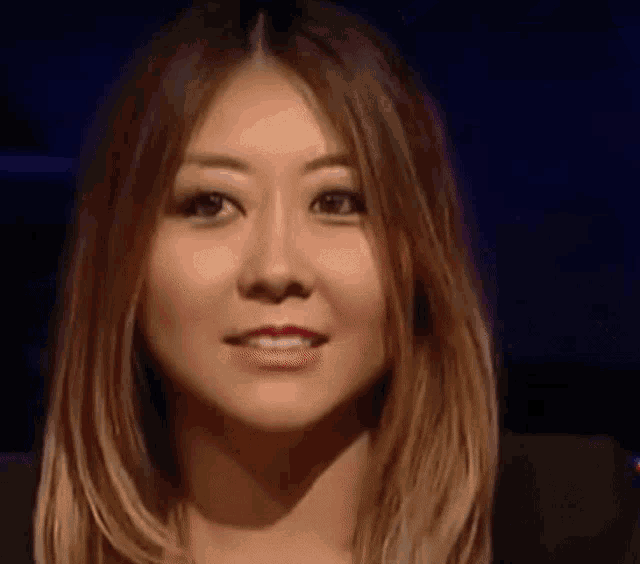a close up of a woman 's face with a dark blue background