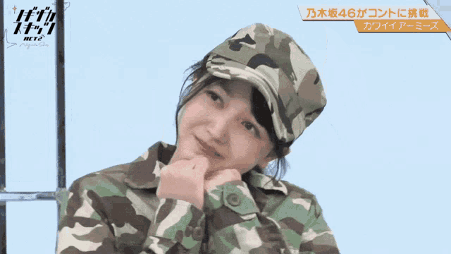 a woman wearing a camouflage jacket and hat making a heart shape with her hands
