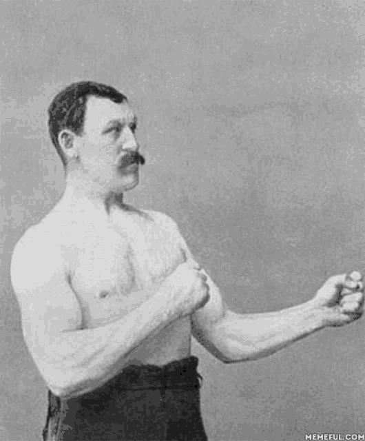 a black and white photo of a shirtless man with a mustache standing with his arms crossed .