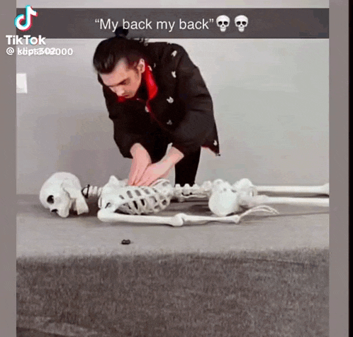 a man is standing next to a skeleton that says my back my back
