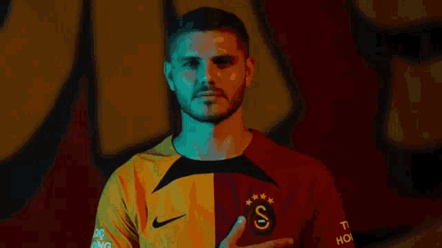 a man wearing a yellow and red shirt with the letter s on the front