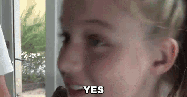 a close up of a woman 's face with the word yes written on it .