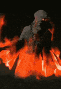 a ghost with red eyes is surrounded by fire in the dark