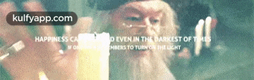 a man with a beard is holding a candle in front of a screen that says kulfyapp.com on it