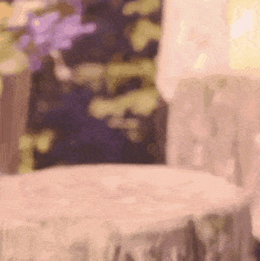 a blurry picture of a table and chairs with a purple background .