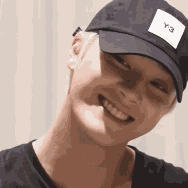 a man wearing a black hat with a y-3 logo on it