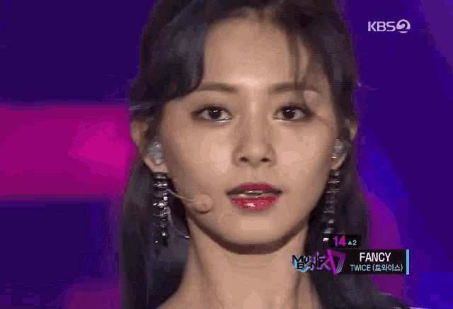 a close up of a woman 's face wearing a microphone and earrings