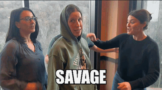 a woman wearing a green hoodie with the word savage on the front