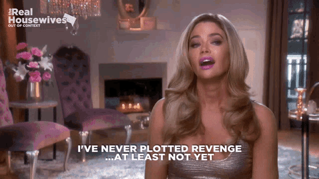 a woman says " i 've never plotted revenge at least not yet " in front of a fireplace