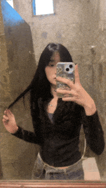a woman is taking a selfie in a bathroom with her phone